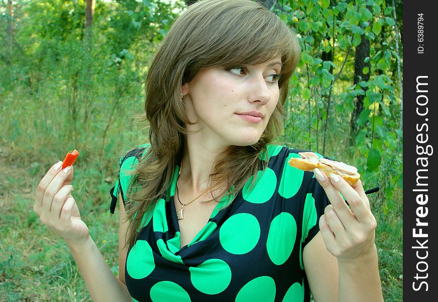 The girl eats in a picnik. The girl eats in a picnik