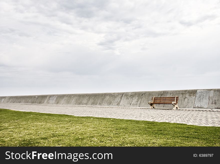 Single bench on breakwater before storm - landscape exterior