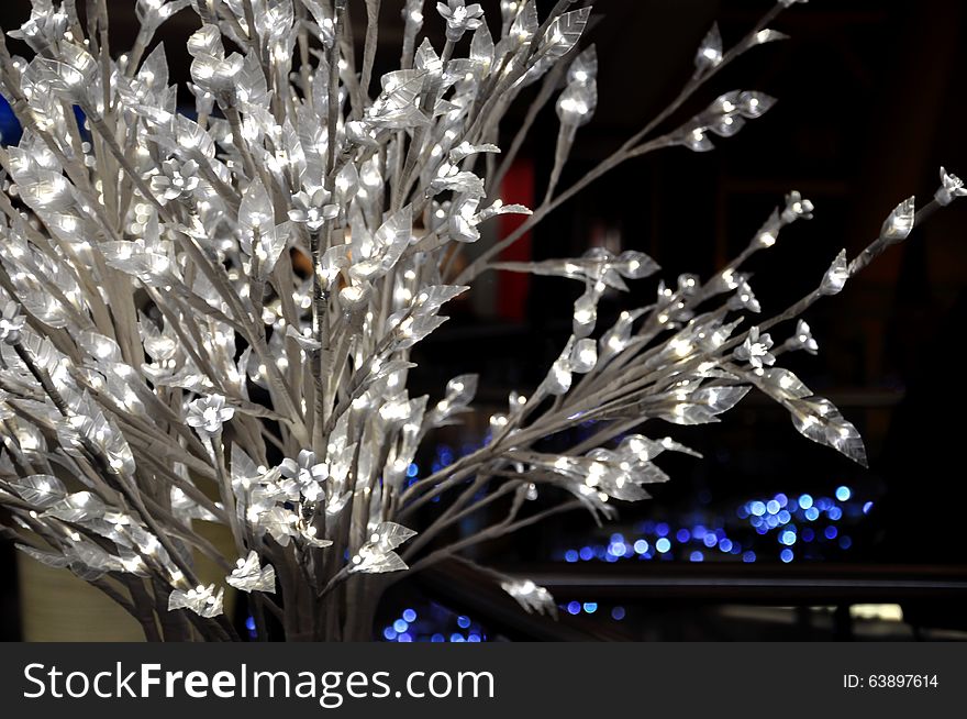 White bush with glowing lights bulbs in shopping mall. Christmas decoration. White bush with glowing lights bulbs in shopping mall. Christmas decoration.
