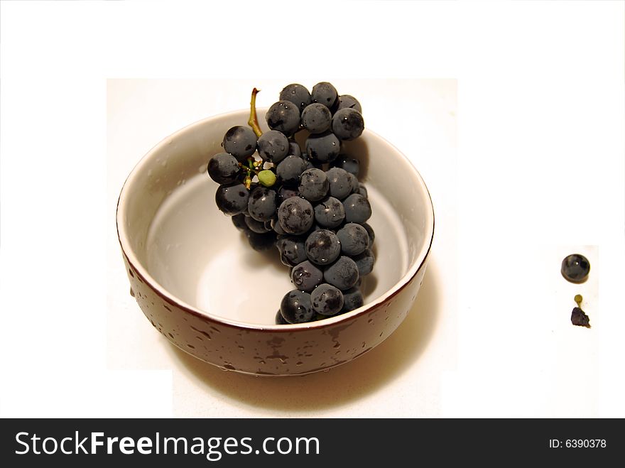 Black grape details. sweet wine grapes in a bowl isolated on white background. Black grape details. sweet wine grapes in a bowl isolated on white background.