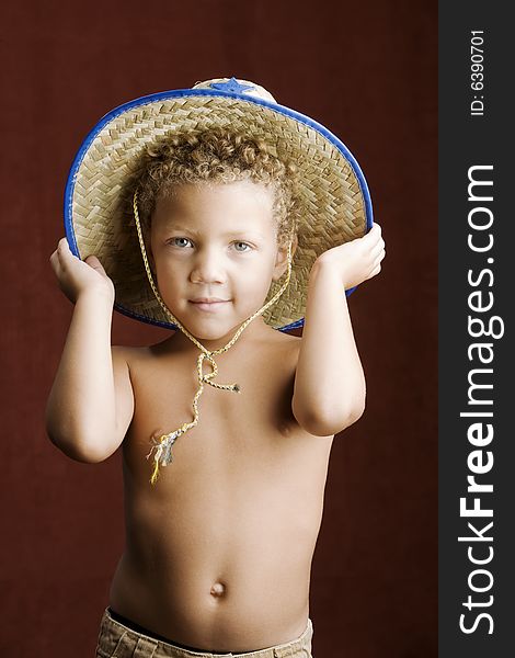 Little boy with curly hair and blue eyes in a sheriff hat. Little boy with curly hair and blue eyes in a sheriff hat