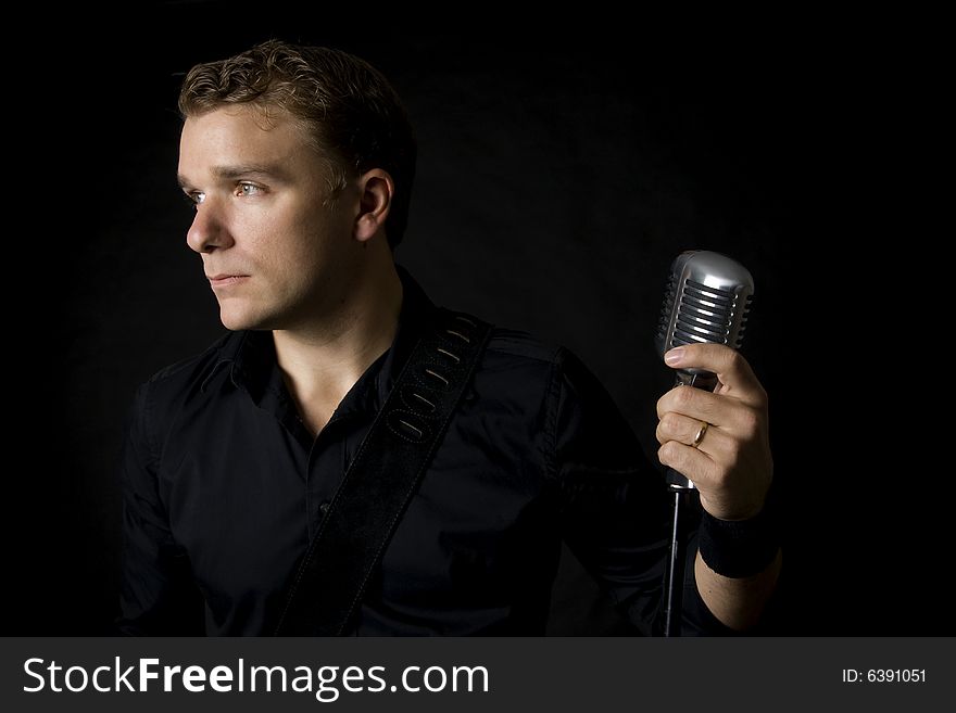 Portrait of young musician holding his microphone