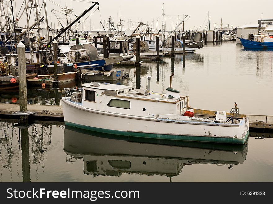 An old green and white fishing boat at a harbor