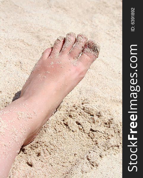 Foot in gold dust on the beach. Foot in gold dust on the beach