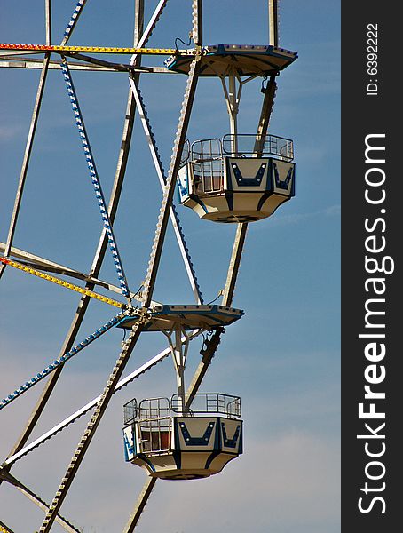 Cars of a large Ferris wheel await passengers. Cars of a large Ferris wheel await passengers.