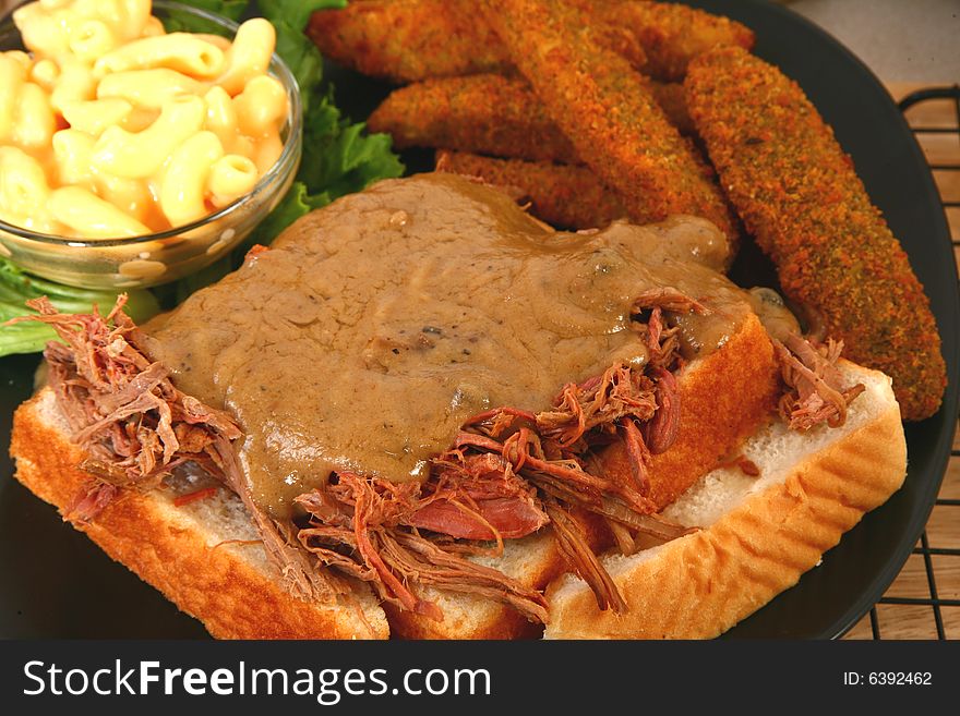 Open beef sandwich with gravy, macaroni and fried pickles. Open beef sandwich with gravy, macaroni and fried pickles.