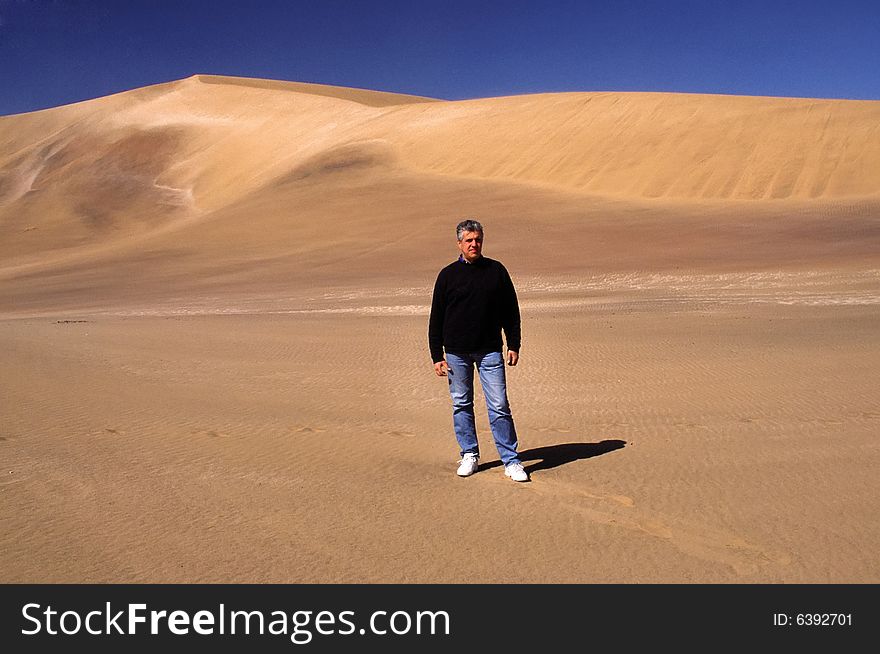 A view of the nature in the desert of namibia, a man walking in the pure desert. A view of the nature in the desert of namibia, a man walking in the pure desert