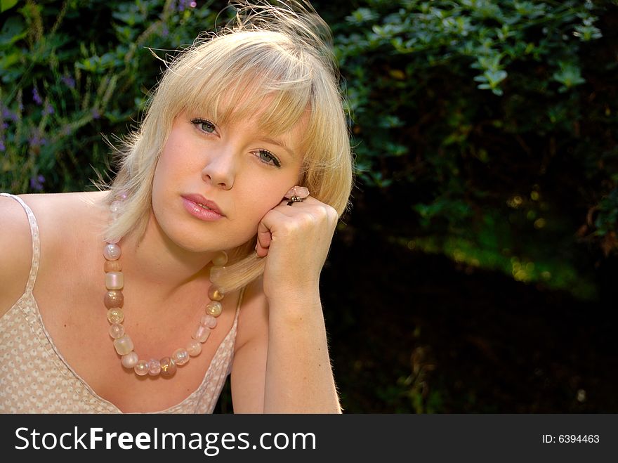 Close portrait of relaxed attractive blond girl in garden