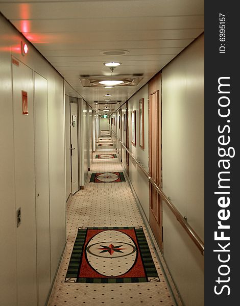 Cruise ship hallway with staterooms on either side.