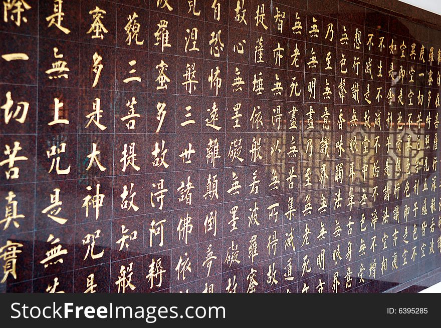 Chinese characters in red written on stone background