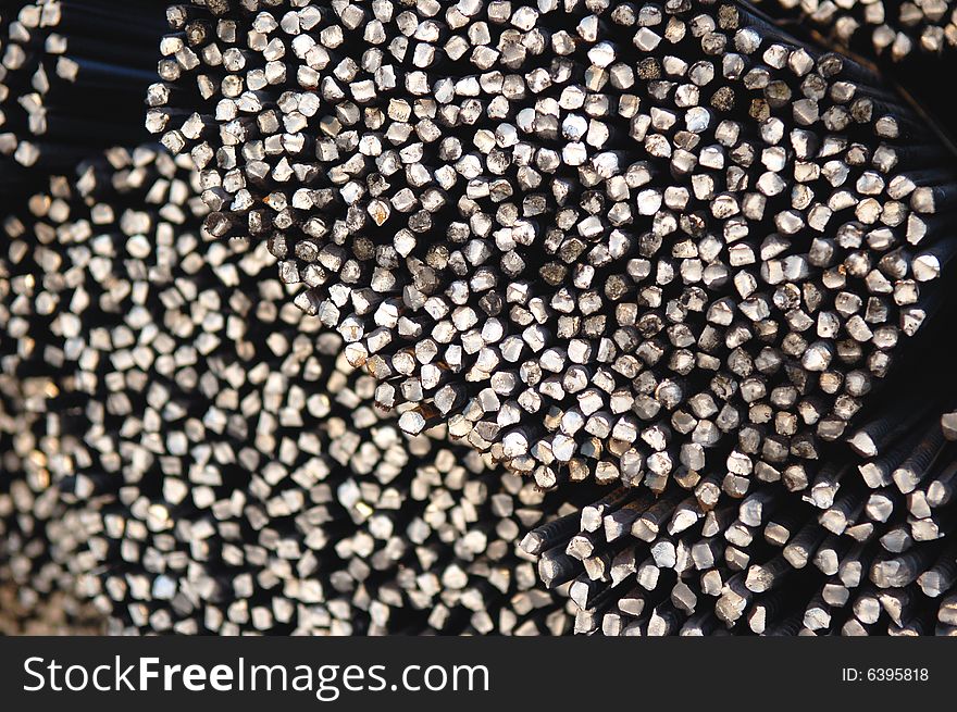 Macro of a tied bundle of cold steel bars on construction site. Macro of a tied bundle of cold steel bars on construction site