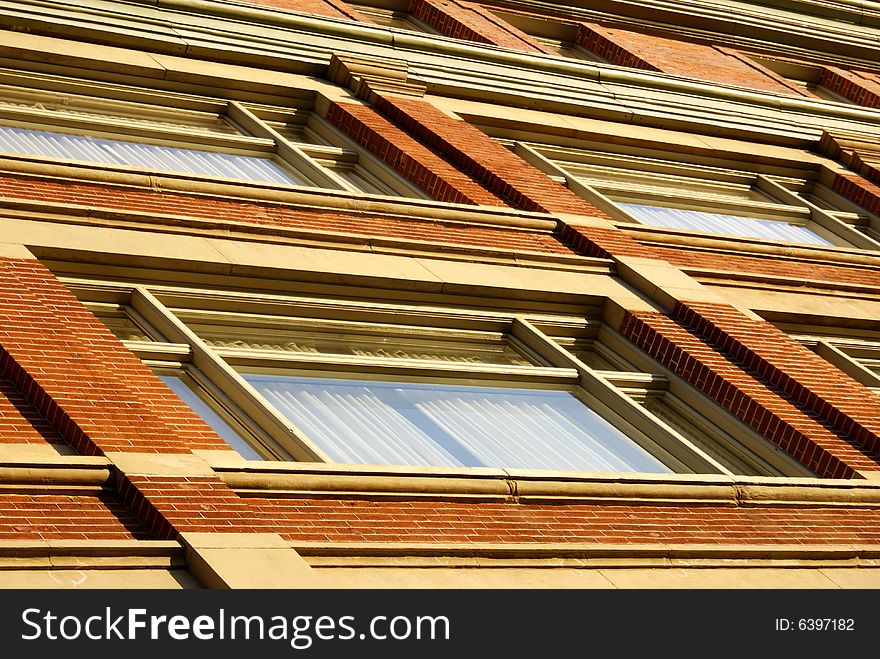 Angled shot of a red-brick wall with windows in Denver Colorado.