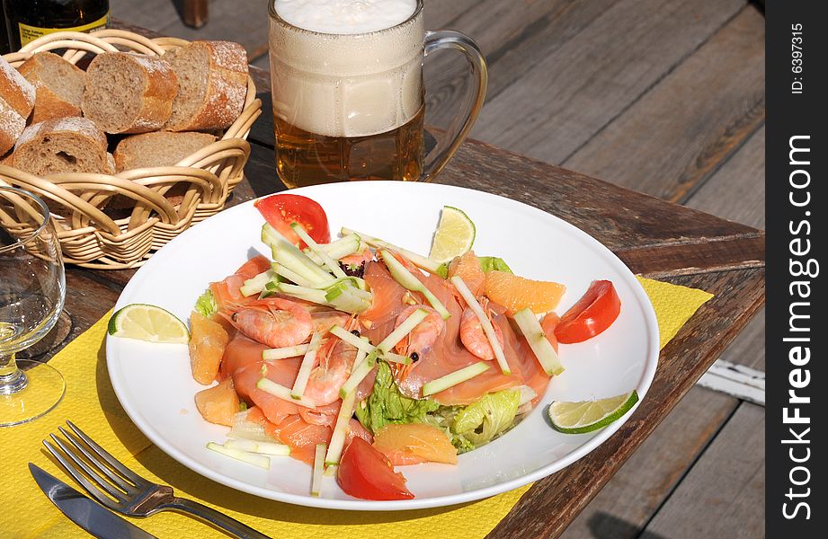 Dinner on terrace with seafood salad and beer