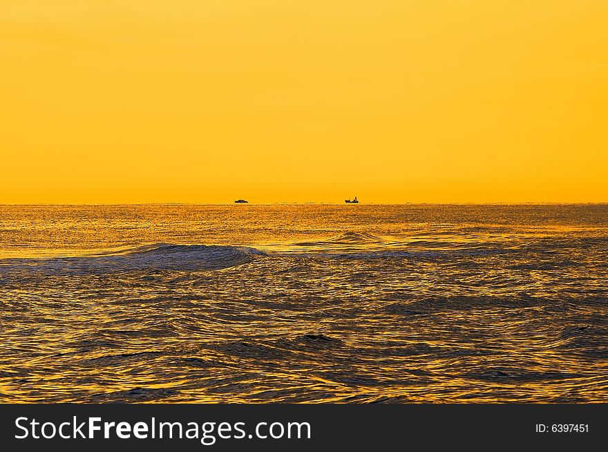 Seascape in the morning yellow lights. Two ships on horizon. Seascape in the morning yellow lights. Two ships on horizon.