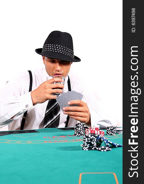 Young man playing poker with a hat and stylish suit. Isolated over white background.