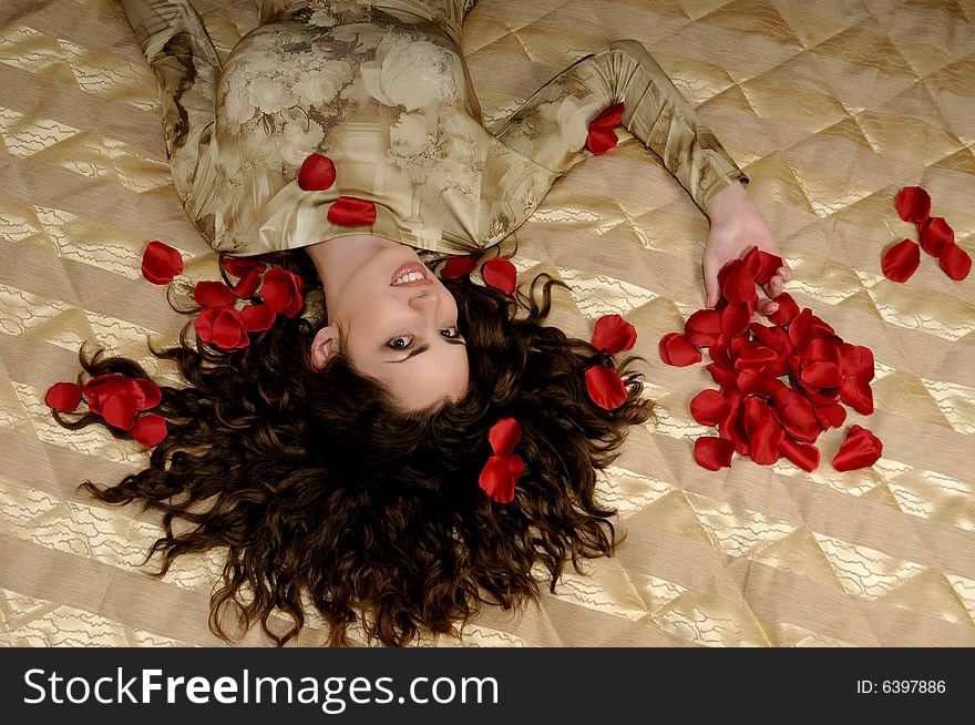 Beautiful smiling woman with red rose petals. Beautiful smiling woman with red rose petals