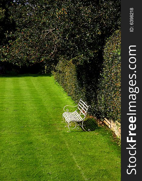 A garden bench in a peaceful spot in the garden. A garden bench in a peaceful spot in the garden