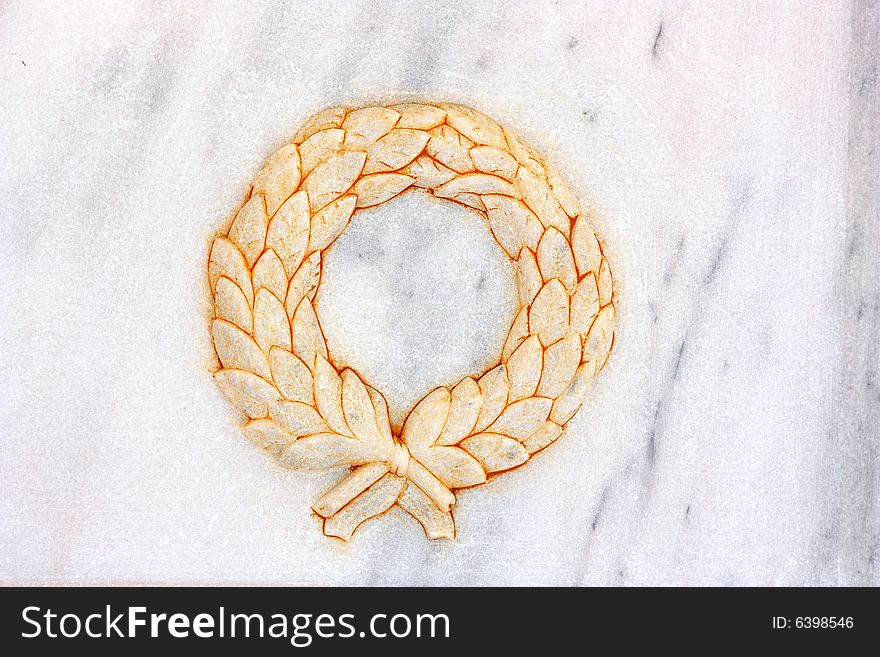 A wreath sculpted on white and grey marble. A wreath sculpted on white and grey marble