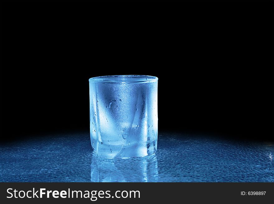 Glass of cold water standing on dark background. Glass of cold water standing on dark background