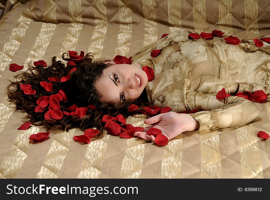 Beautiful smiling woman with red rose petals. Beautiful smiling woman with red rose petals