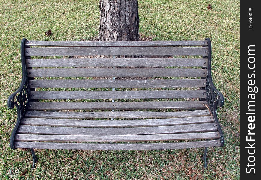 Garden chair in the middle of grass with a tree in the background. Garden chair in the middle of grass with a tree in the background