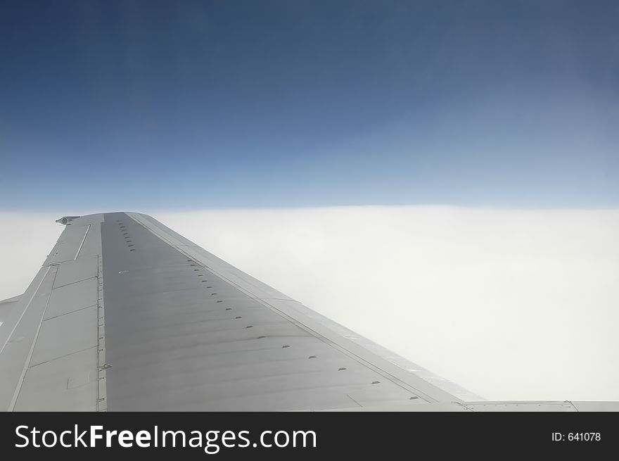 Airplane's wing over blue sky and white clouds. Airplane's wing over blue sky and white clouds