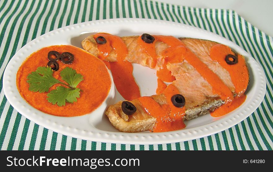 Salmon steak with spicy red sauce and black olives. Salmon steak with spicy red sauce and black olives