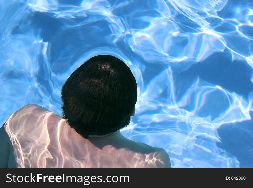 Man swimming peacefully submerged under water. Man swimming peacefully submerged under water