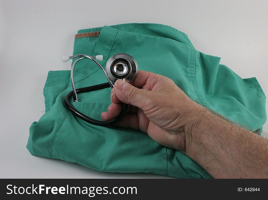 Hand holding stethoscope over smock with white background. Hand holding stethoscope over smock with white background.