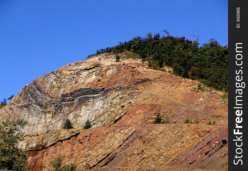 Cut rock - mountain with trees on top. Cut rock - mountain with trees on top