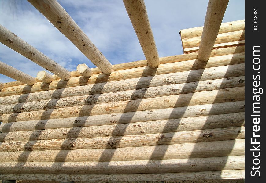 Interior wall and initial roof beams of a log cabin under construction. Interior wall and initial roof beams of a log cabin under construction