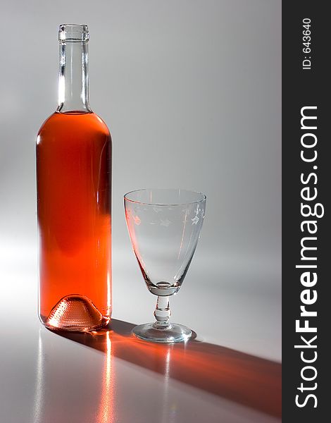 Dramatic studio light on a bottle of wine and glass. Dramatic studio light on a bottle of wine and glass