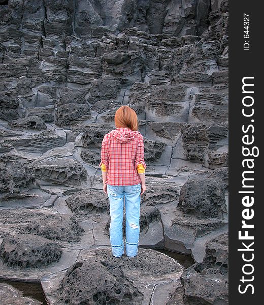 A woman standing on the hexagonal volcanic rock at the Jisatgae Seashore, Jeju Island, Korea. A woman standing on the hexagonal volcanic rock at the Jisatgae Seashore, Jeju Island, Korea