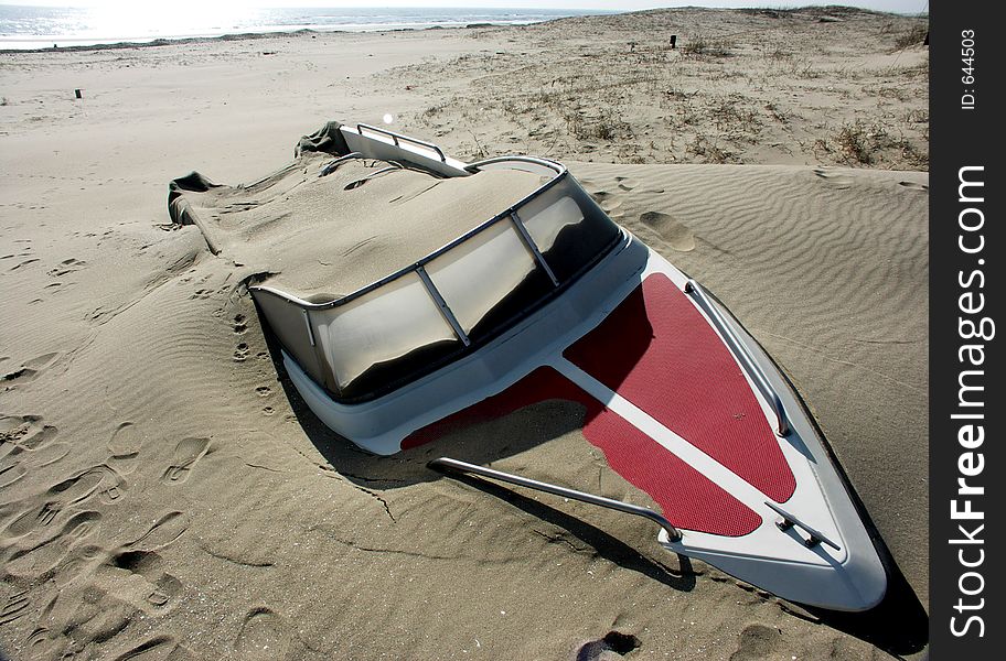 An abandoned speedboat on a beach in china.