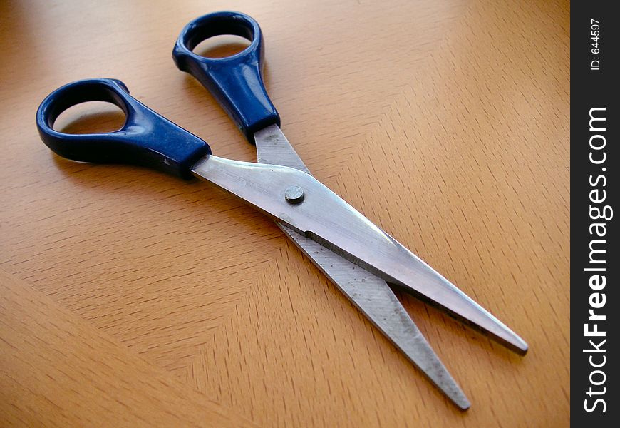 Pair of scissors open on a desk. Pair of scissors open on a desk