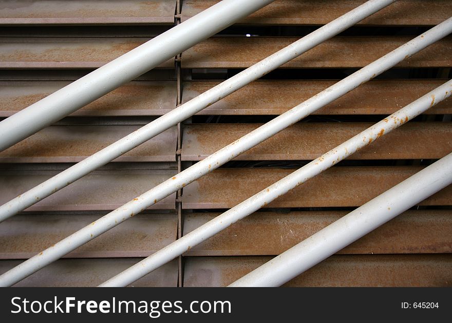 Close up of metal handrail and rusting metal shutters