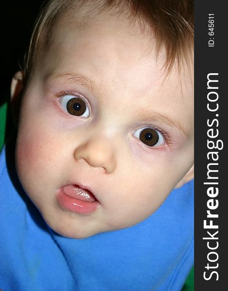 Child caught off-guard while sitting in his highchair waiting to be fed. Child caught off-guard while sitting in his highchair waiting to be fed