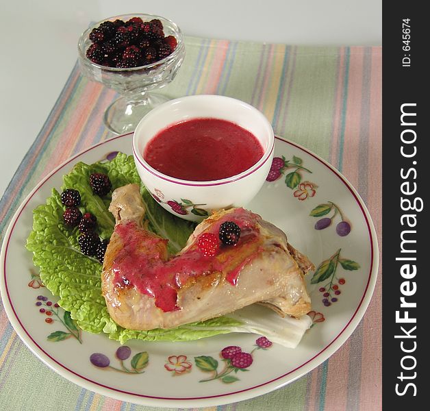 Chicken leg with blackberry sauce on salad leaf