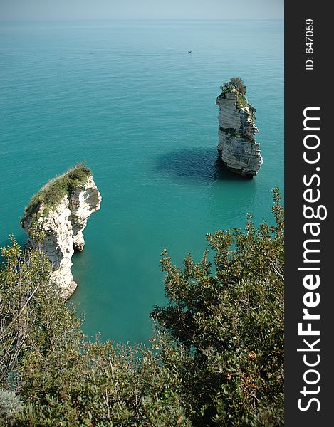 Towers of erroed cliffs come out of the emerald water in the Sdriatic sea in Southern italy. Towers of erroed cliffs come out of the emerald water in the Sdriatic sea in Southern italy