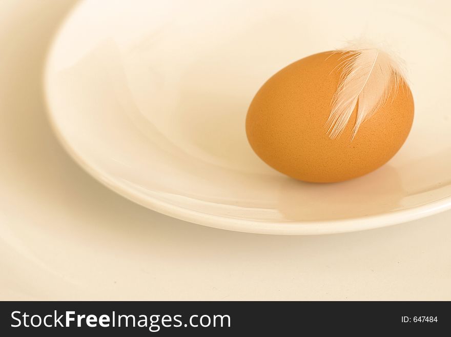 Egg with feather on a plate. Egg with feather on a plate