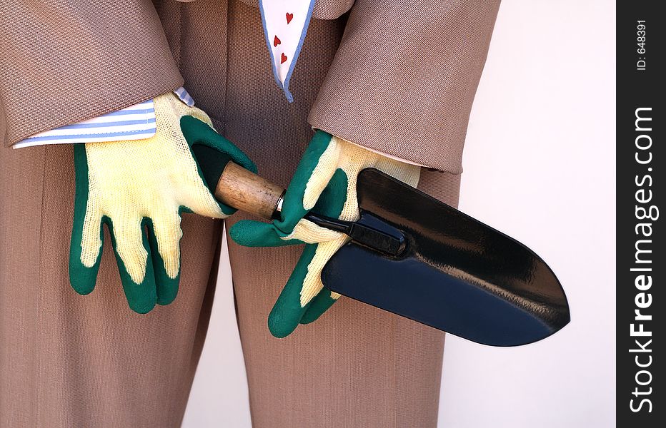 Male mannequin in business suit holding small shovel in hands with gloves. Male mannequin in business suit holding small shovel in hands with gloves