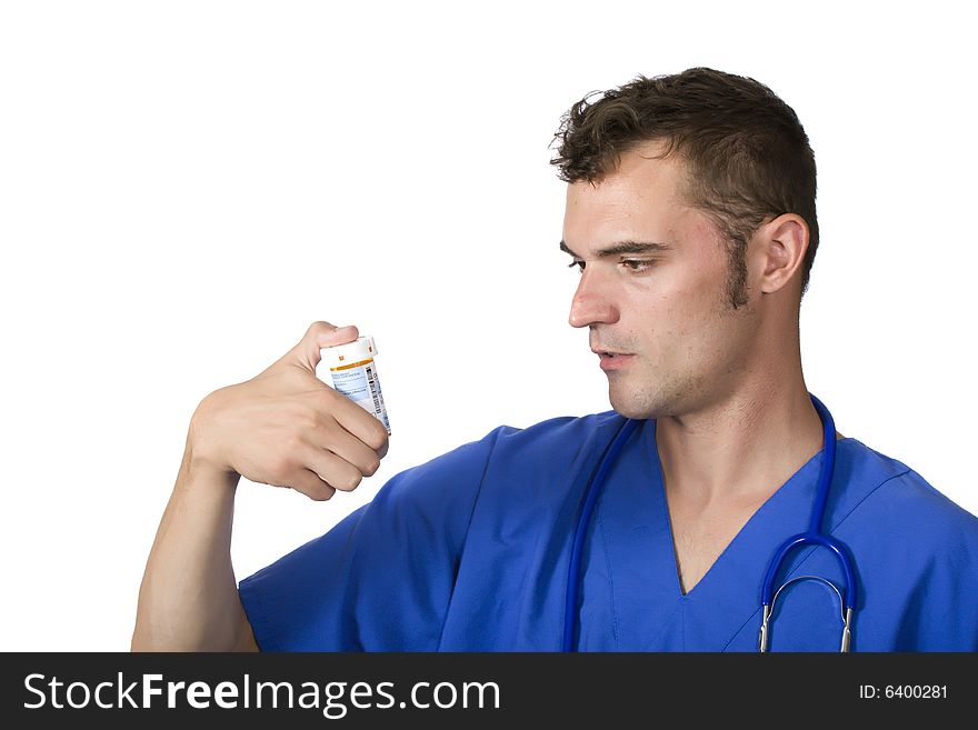 A young doctor or pharmacist looking at a pill bottle. A young doctor or pharmacist looking at a pill bottle