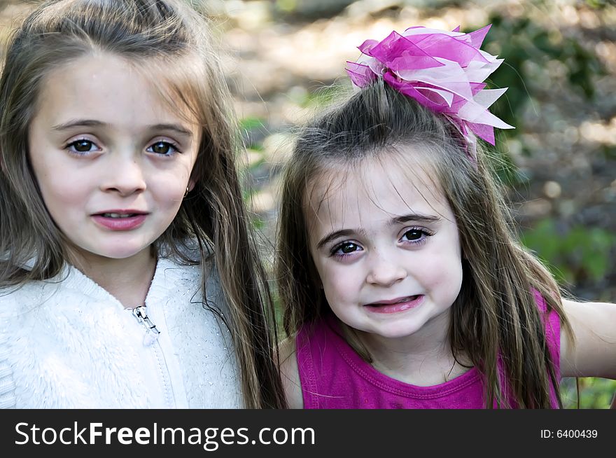 Two beautiful little girls posing with long brown hair and big brown eyes. Two beautiful little girls posing with long brown hair and big brown eyes.