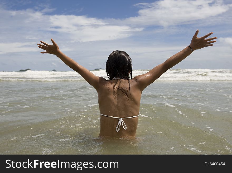 Vacation by the sea, teenager sits on the beach and is happy