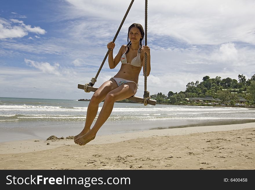 Girl on swing on the beach