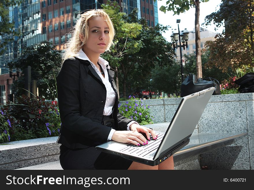 Pretty women sitting outside with a lap top cumputer. Pretty women sitting outside with a lap top cumputer