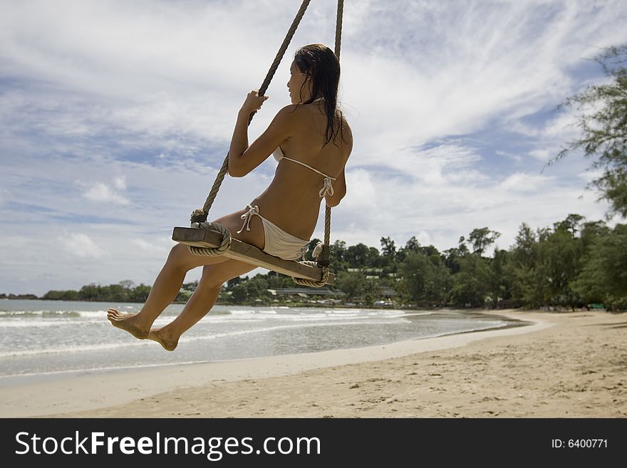 Girl on swing on the beach