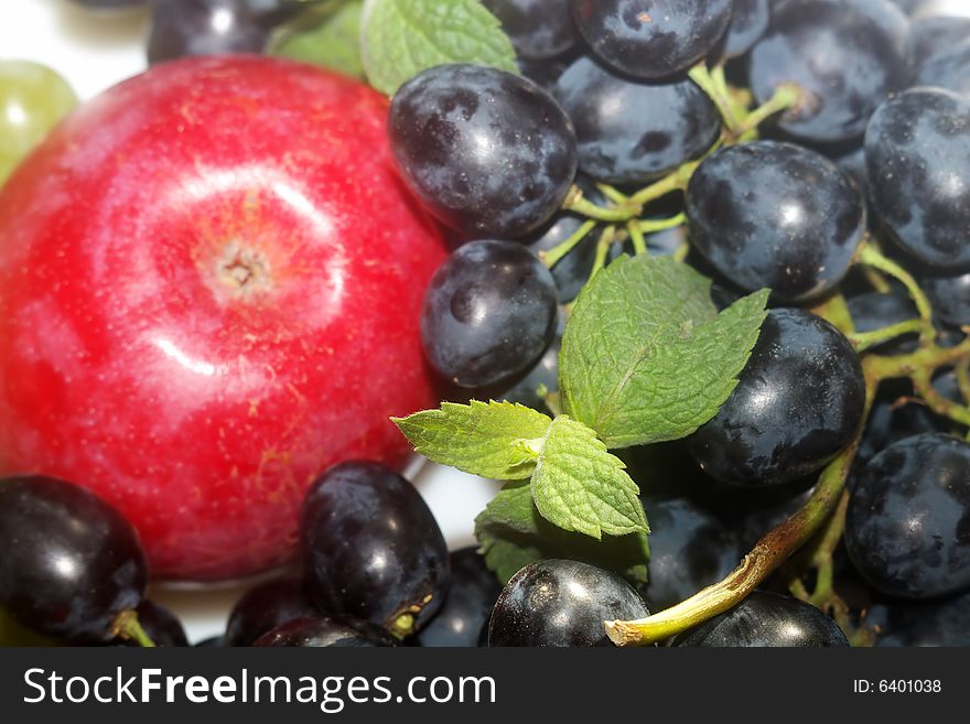 Green and red grapes and red apple