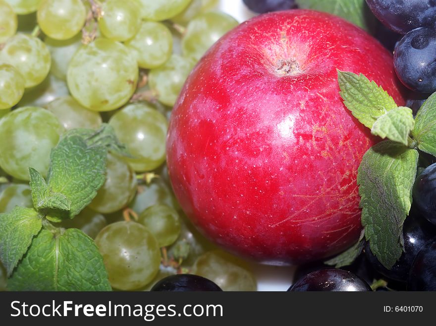 Green and red grapes and red apple