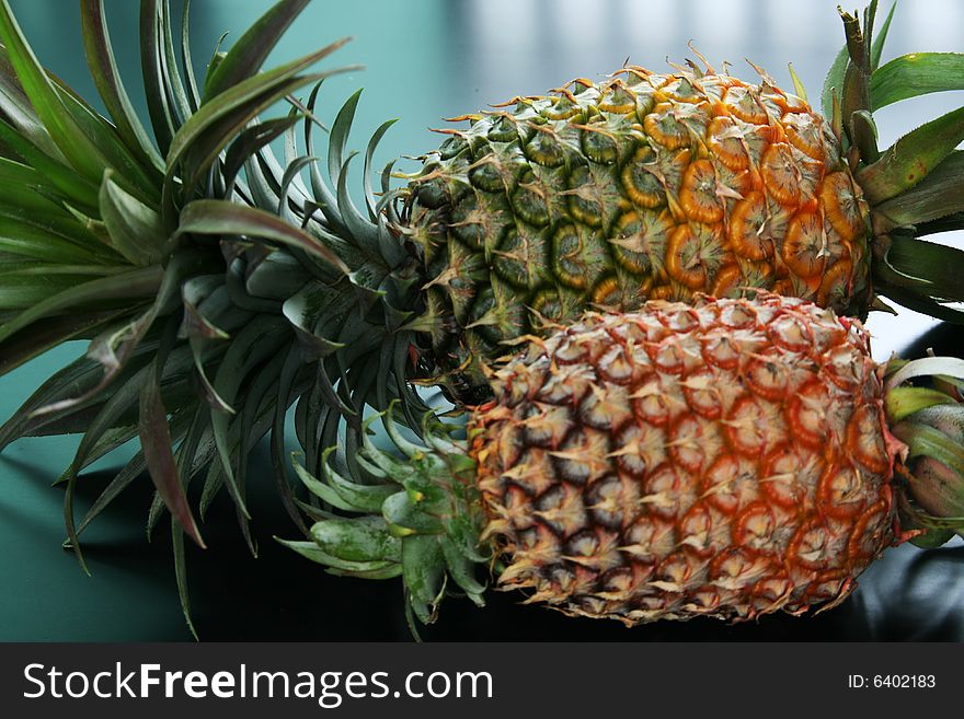 A big pineapple and a small pineapple side by side. A big pineapple and a small pineapple side by side.